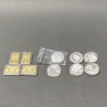 A group of mixed silver and other coins alongside some tokens.