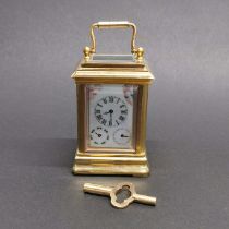 A small gilt brass and porcelain carriage clock, H. 10cm. With day and date functions.