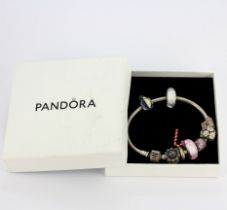 A Pandora bracelet containing eight 925 silver Pandora charms, some are enamelled/stone set.