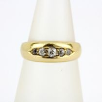 A hallmarked 18ct yellow gold ring set with graduated old cut diamonds, (M.5).