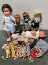 A quantity of vintage dolls and dolls clothes.