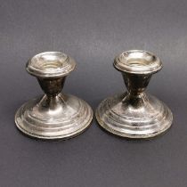 A pair of weighted sterling silver candle sticks, H. 7cm.