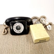 A vintage black telephone and bell.