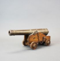 A brass and wood miniature cannon, L. 30cm.