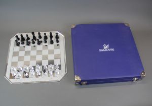A leather cased Swarovski crystal glass chess board and pieces, case size 37 x 37cm.