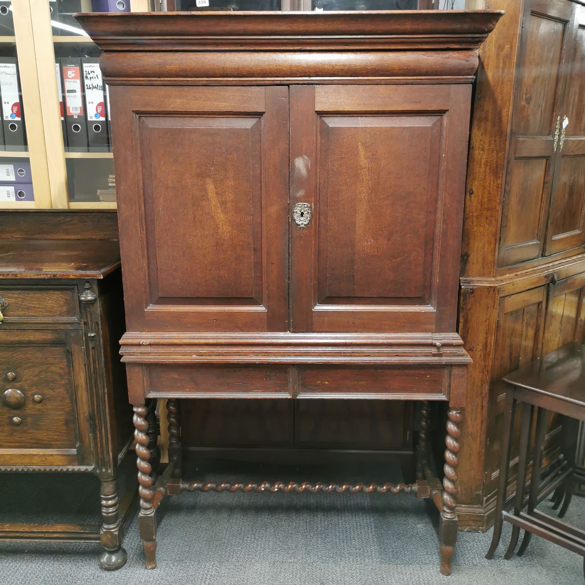 A thirteen drawer oak Cromwellian style cabinet desk with a pull out writing platform and a large