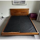 A king-size Revo walnut framed bed featuring a 'floating' base and a curved veneered headboard