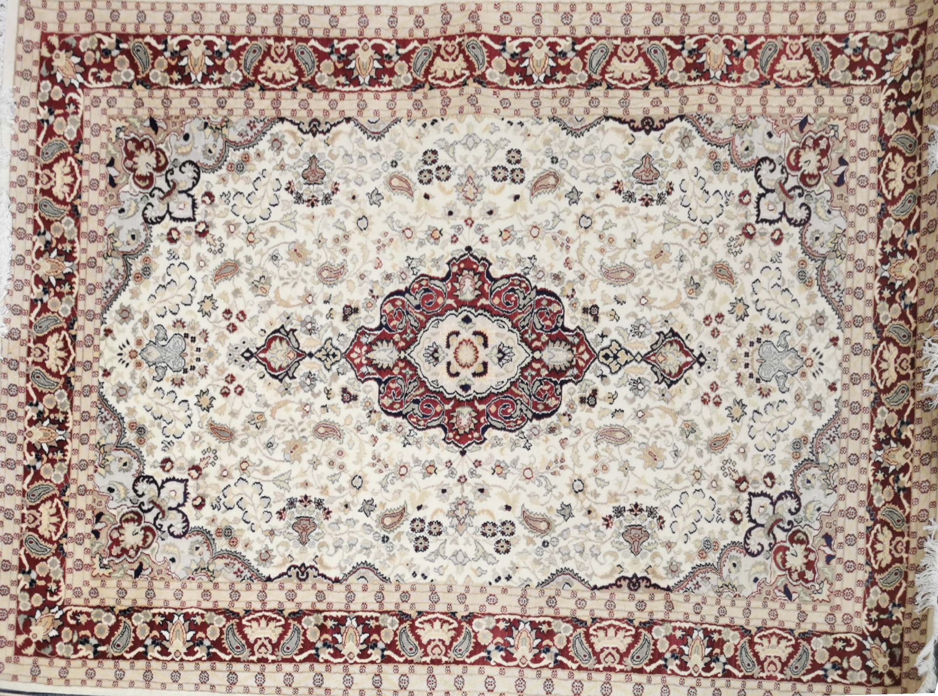An eastern cream, beige and red ground wool rug, 280 x 185cm.