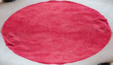 A circular red rug, W. 220cm.