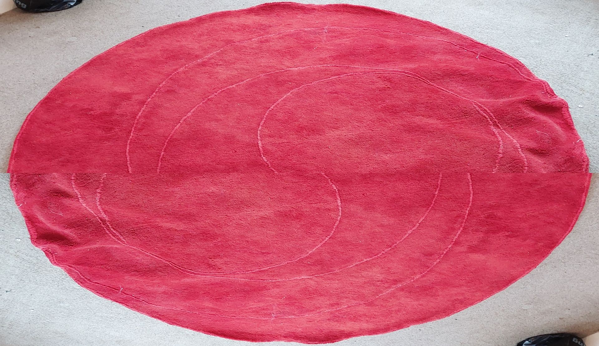 A circular red rug, W. 220cm.