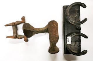 A cast iron horse shoe coat rack and two further metal items.