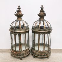 A pair of bronzed metal and glass storm lanterns, H. 60cm.