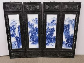 A set of four hand painted porcelain panels set in carved wooden frames, size 36 x 120cm.