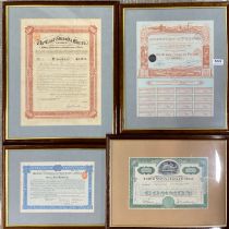 A group of four framed historic share certificates.