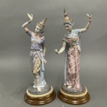A pair of Lladro figures of Thai dancers on turned wooden bases, H. 37cm, one a/f to the top of