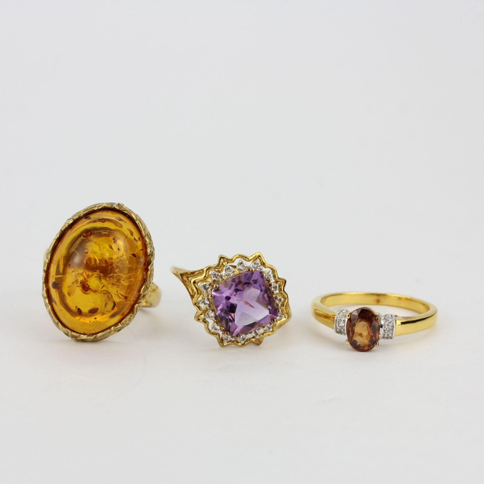 Three 925 silver gilt stone set rings including amber, amethyst and citrine.