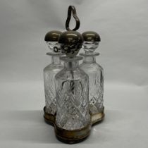 An unusual silver plate and cut crystal three bottle tantalus, H. 35cm.