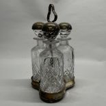 An unusual silver plate and cut crystal three bottle tantalus, H. 35cm.