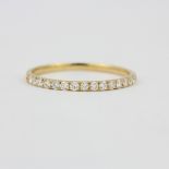 An 18ct yellow gold diamond set half eternity ring, (O).