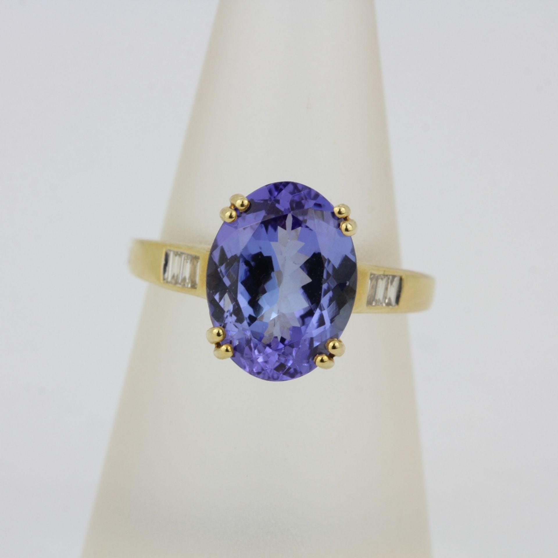 A hallmarked 14ct yellow gold ring set with a large oval cut tanzanite and baguette cut diamond - Image 3 of 3