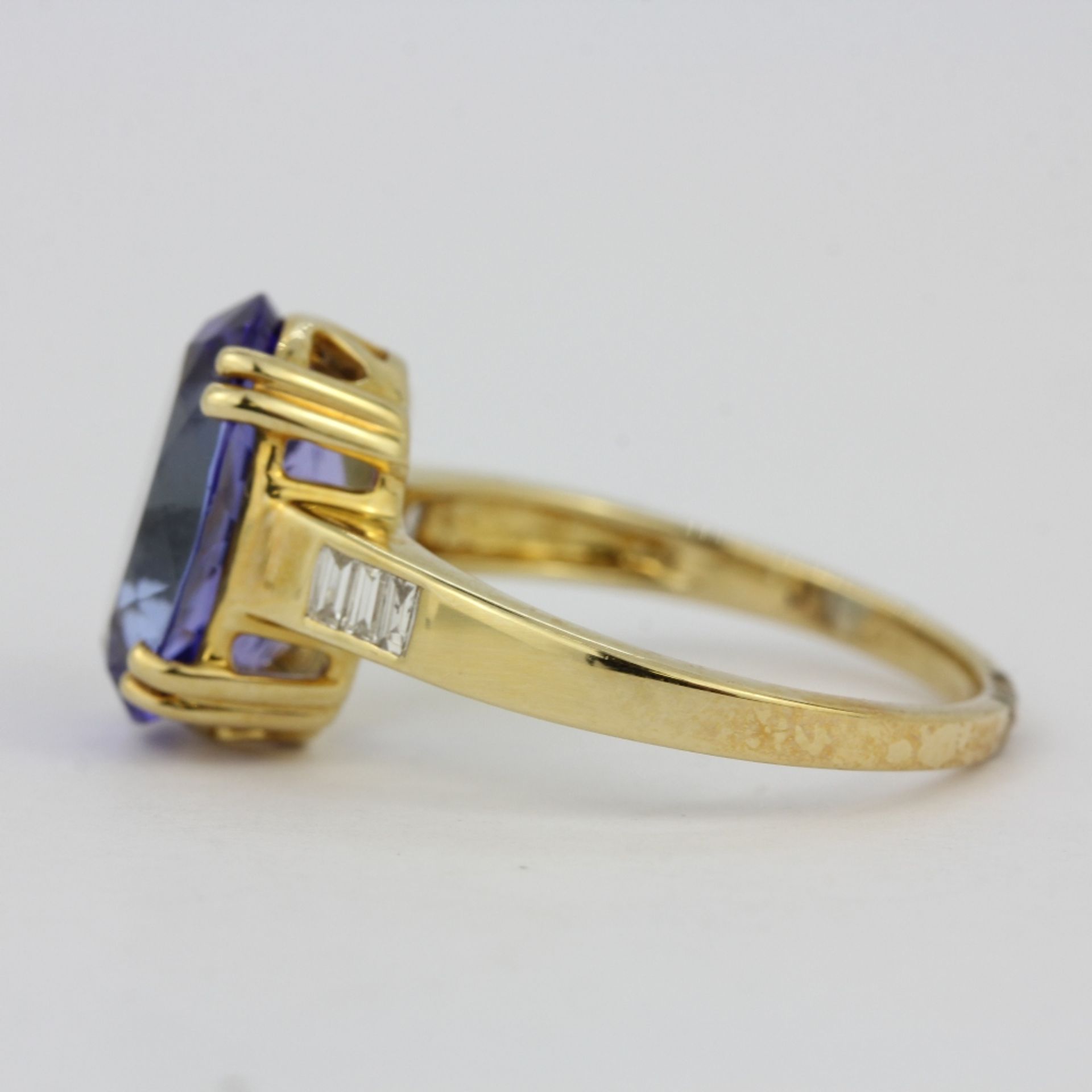 A hallmarked 14ct yellow gold ring set with a large oval cut tanzanite and baguette cut diamond - Image 2 of 3
