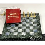 A polished marble chess board with a set of plastic medieval chess pieces, 35 x 35cm.