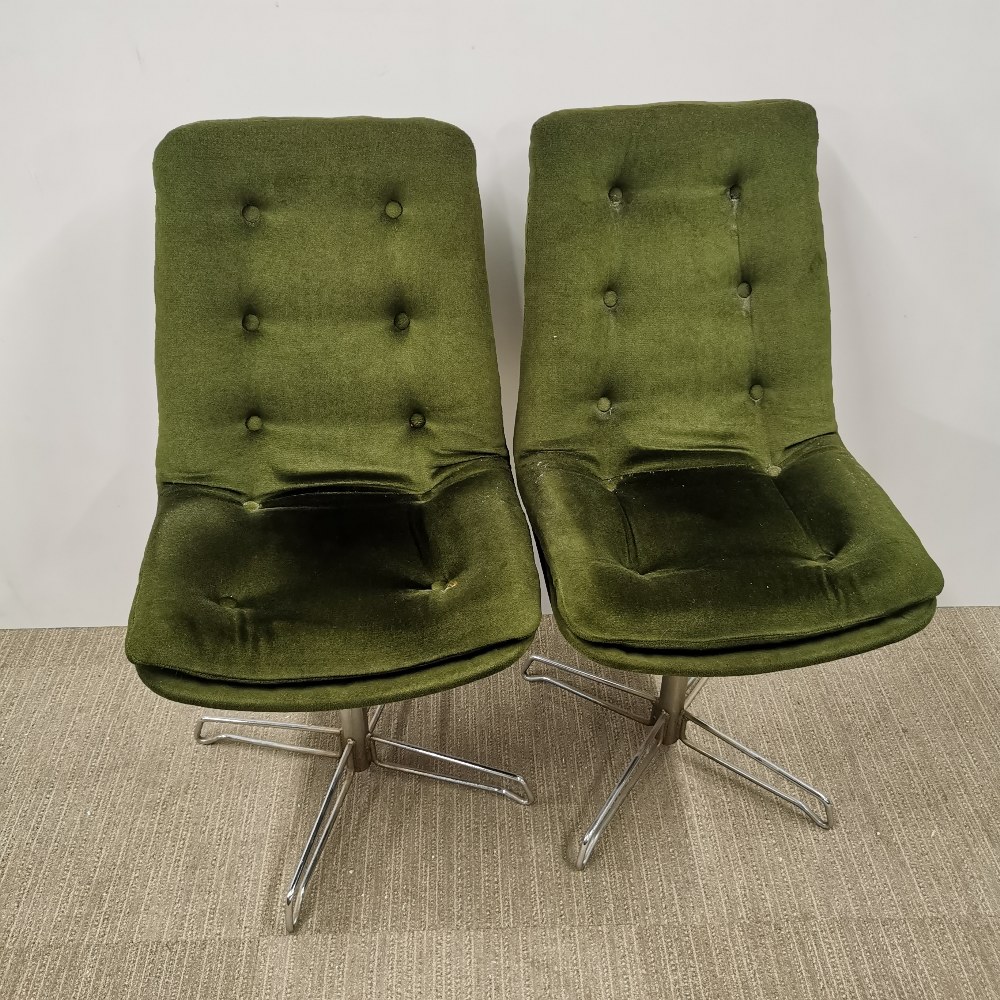 A pair of vintage revolving button backed chrome chairs upholstered in a green fabric, H. 92cm.