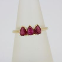 A hallmarked 9ct yellow gold ring set with pear cut rubies, (O).