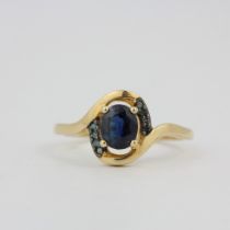 A hallmarked 9ct yellow gold ring set with an oval cut Nigerian sapphire and blue diamonds, (O).