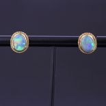 A pair of yellow metal opal set stud earrings, L. 1cm. With 18ct gold backs.