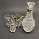 A cut crystal decanter with a hallmarked silver collar, together with a pair of silver overlaid