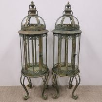 A pair of metal and glass garden storm lanterns, H. 80cm.