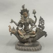 A Tibetan bronze figure of a Tara seated on a mythical fish, H. 26cm.