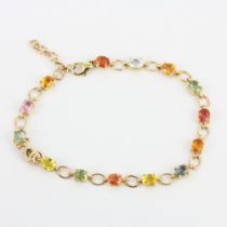 A 10ct yellow gold (marked 10K) bracelet set with multi coloured oval cut sapphires, L. 21cm.