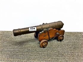 A brass and wood miniature cannon, L. 30cm.