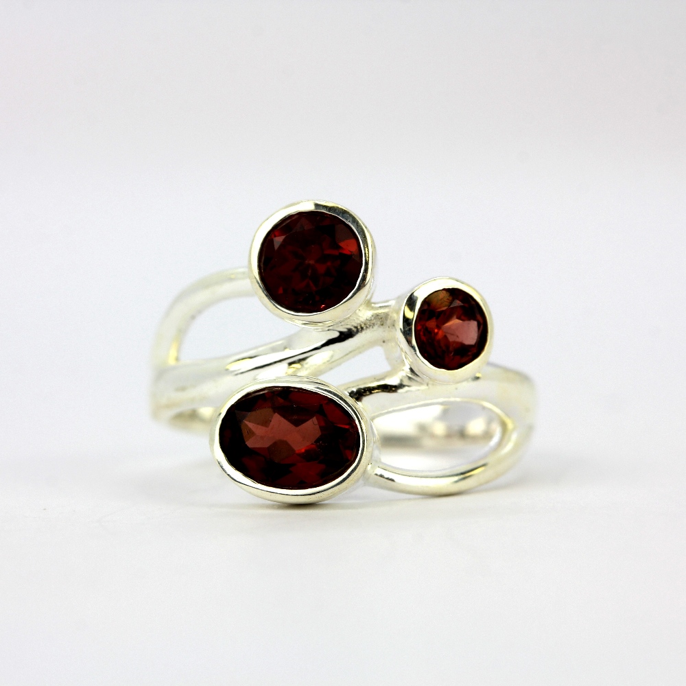 A 925 silver ring set with oval and round cut garnets.