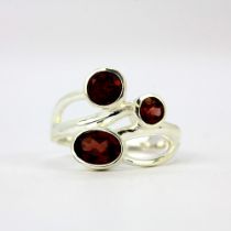 A 925 silver ring set with oval and round cut garnets.