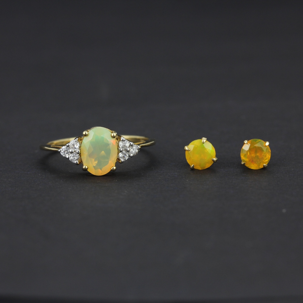 A 10ct yellow gold ring set with an oval cut opal and white topaz, (O), together with a pair of 10ct
