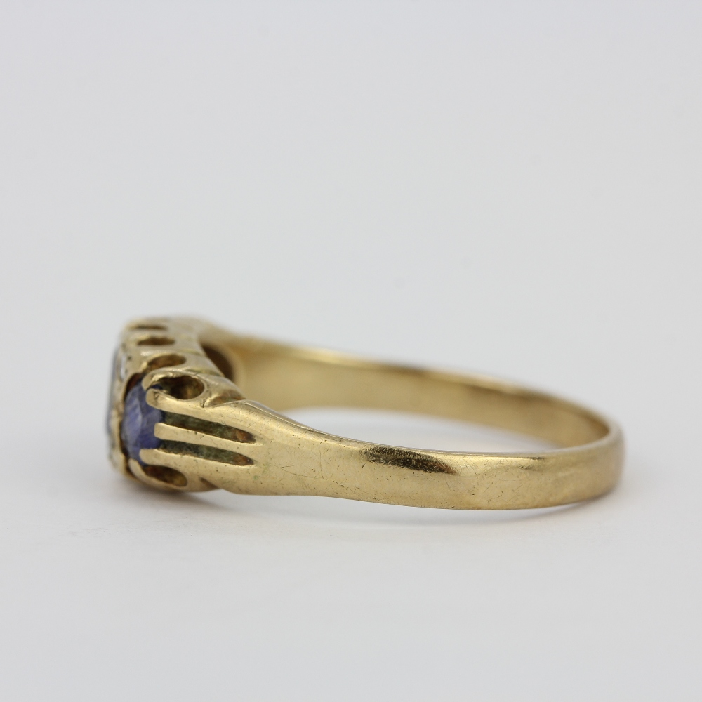 A yellow metal (tested minimum 9ct gold) ring set with ceylon sapphires and diamonds, (O). - Image 2 of 3