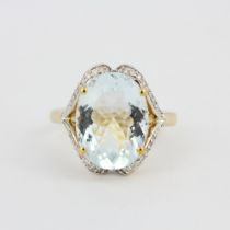 A hallmarked 14ct yellow gold ring set with a large oval cut aquamarine, L. 1.4cm, and diamonds, (