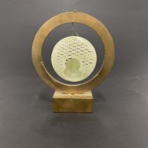 A Chinese finely carved jade disc featuring Lao Shou Xing suspended in a bronze frame H. 11cm.