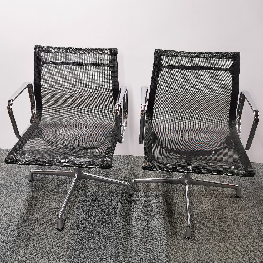 A pair of revolving Eames Vitra type chrome desk chairs, H. 82cm.