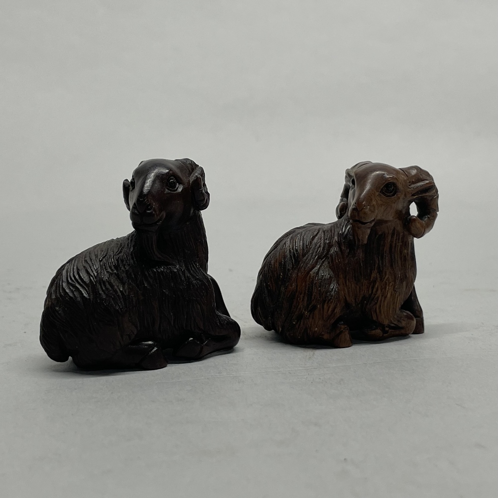 Two Chinese carved wooden netsuke of rams, H. 4.5cm.