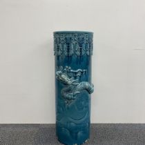 A large Chinese glazed ceramic umbrella stand, relief decorated with a dragon. Some chipping