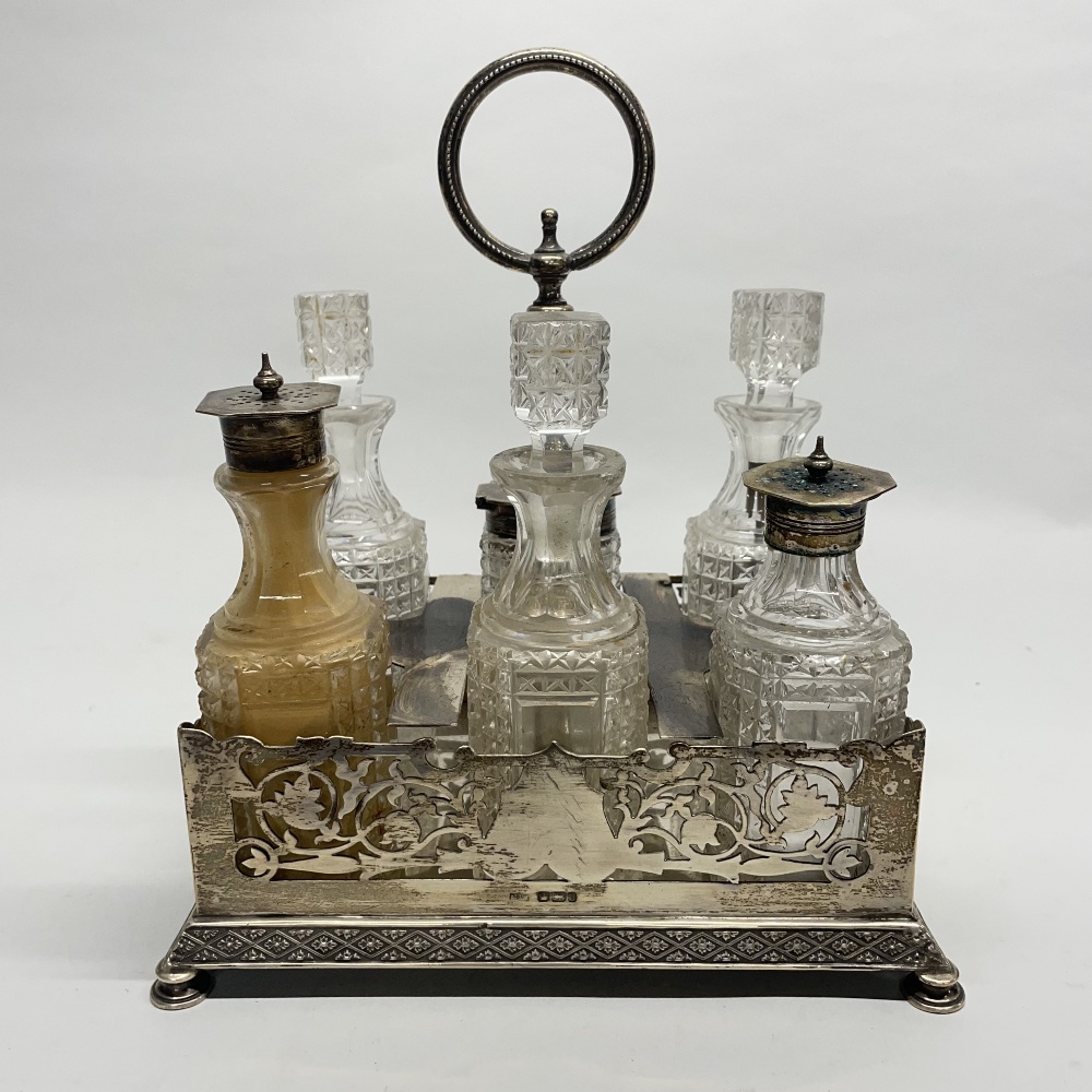 A hallmarked silver Mappin and Webb condiment tray with cut crystal and silver plate topped bottles,