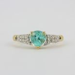 A hallmarked 18ct yellow gold ring set with a pear cut paraiba tourmaline and diamond shoulders, (