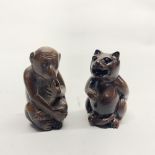 A Chinese carved wooden netsuke of a monkey, together with a further carved wooden netsuke of a cat,