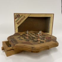 An inlaid wooden chess board and chess set and a boxed bagatelle, chess board Dia. 32cm.