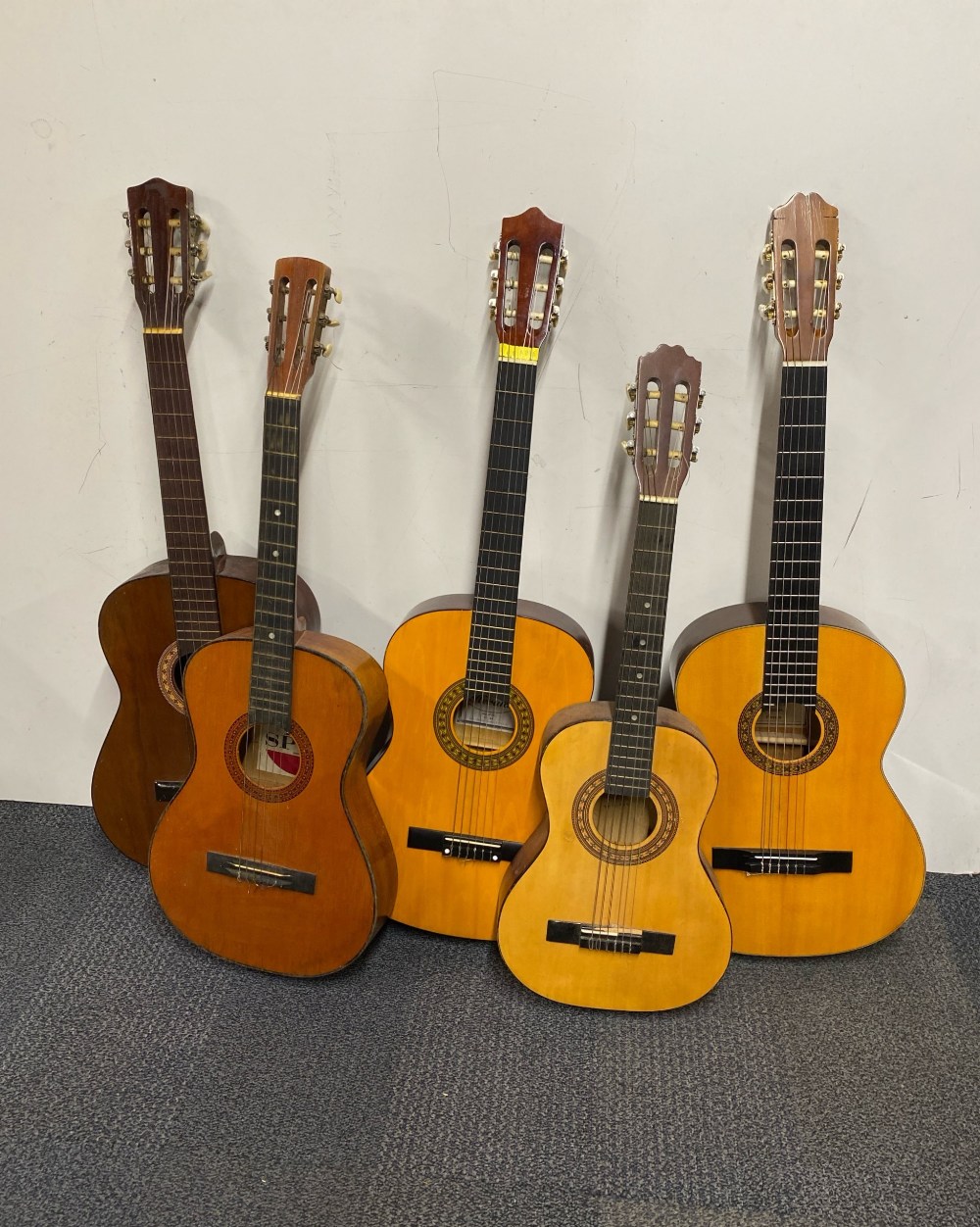 A group of five cased acoustic guitars.