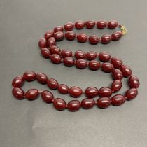 A long faux cherry amber necklace, L. 108cm.